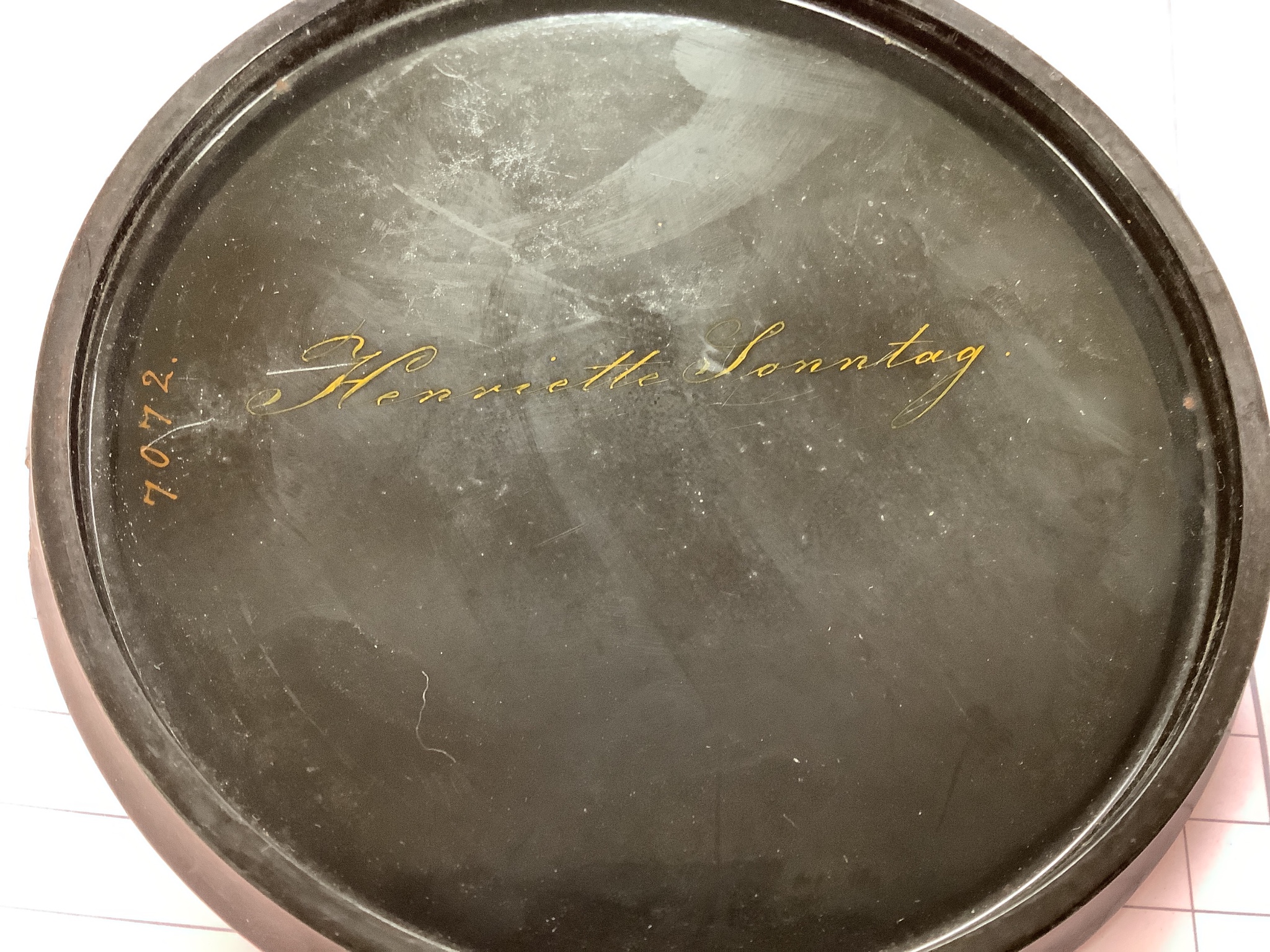 A 19th century Stobwasser papier mache ‘Henriette Sonntag’ portrait snuff box, c.1830, 9.7cm diameter and a 19th-century papier mache snuff box painted with a portrait of a German hussar, 9.4cm (2)